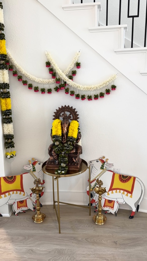 Ganesha vignette with yellow garlands and painted cow cutouts