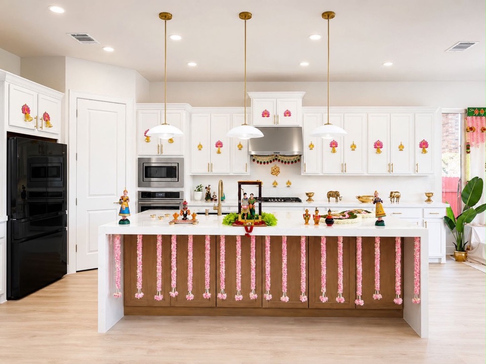 A new home kitchen styled for a housewarming with lotus motifs on the cabinets, garlands and brass pieces