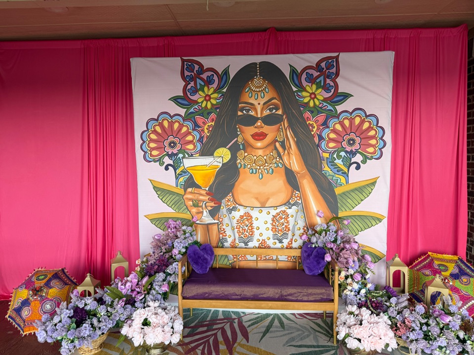 Mehendi lounge with painted mural, pink drape and lavender florals