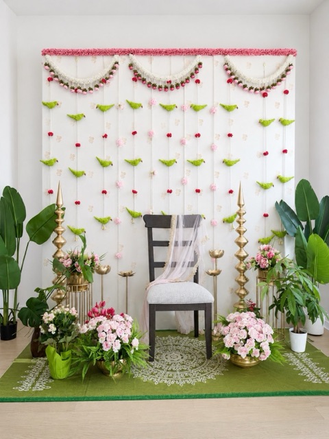 White backdrop with green parrot garlands and pink roses